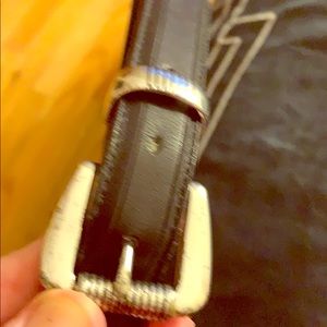 One men’s black leather belt with silver hardware